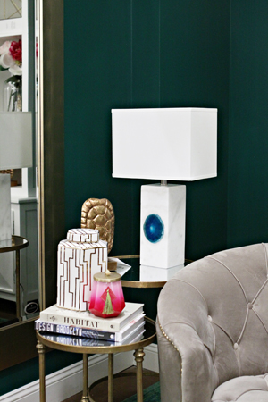 A shot of the book arrangement next to an beautiful modern lamp.